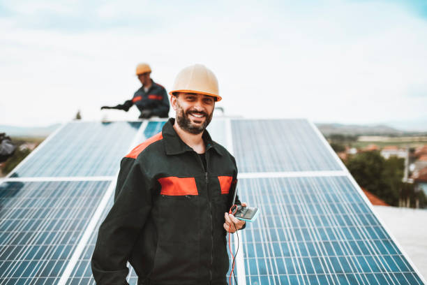 istock Smiling Worker Finished Installing Solar Pannels On Building Rooftop With Colleague 1322547291