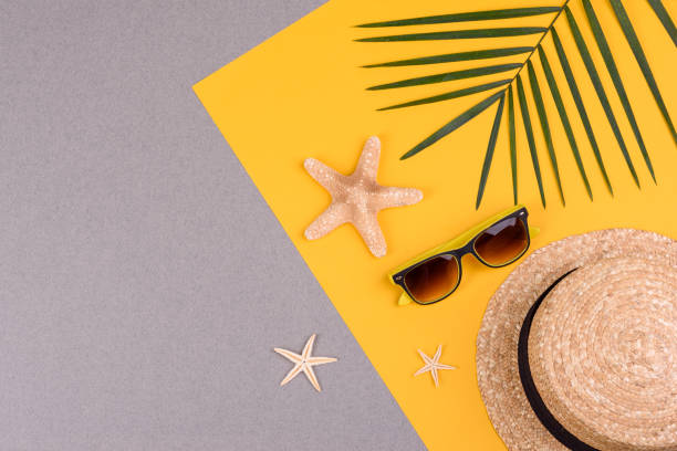 istock Beach accessories: glasses and hat with shells and sea stars on a colored background. Summer background 1322547582