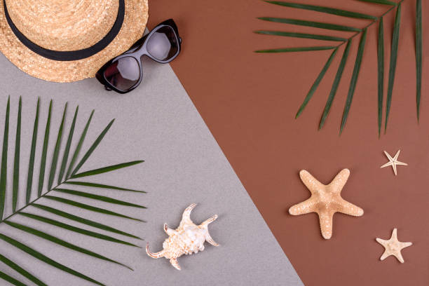 istock Beach accessories: glasses and hat with shells and sea stars on a colored background. Summer background 1322547623