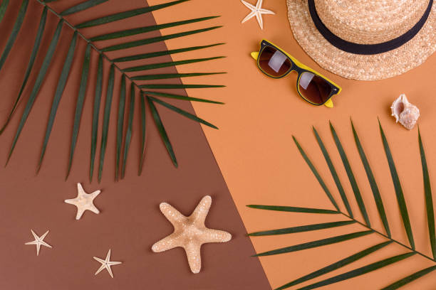 istock Beach accessories: glasses and hat with shells and sea stars on a colored background. Summer background 1322547624