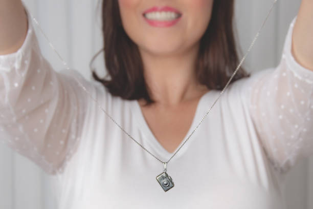 elegant woman holding camera necklace