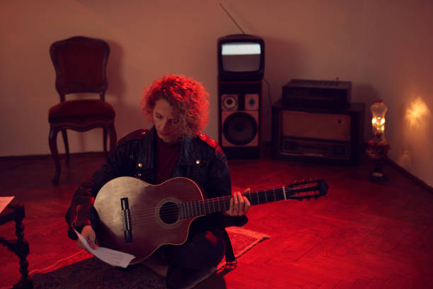 woman playing acoustic guitar in a retro vintage room. - fingerstyle imagens e fotografias de stock