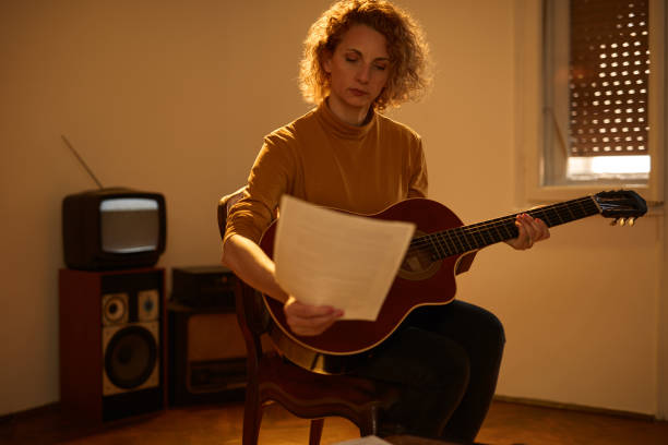 woman playing acoustic guitar in a retro vintage room. - fingerstyle imagens e fotografias de stock