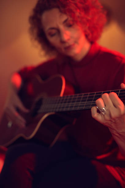 woman playing acoustic guitar in a retro vintage room. - fingerstyle imagens e fotografias de stock