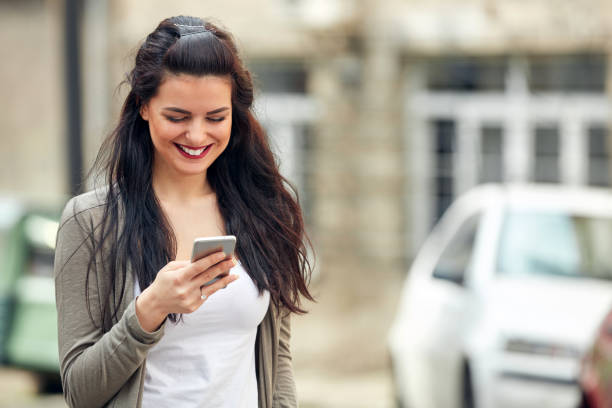 istock Young cute female using smartphone on the street. 1322549715