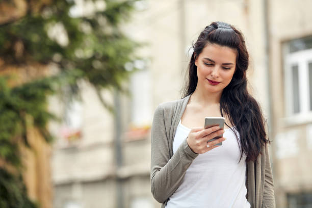 istock Young cute female using smartphone on the street. 1322549743