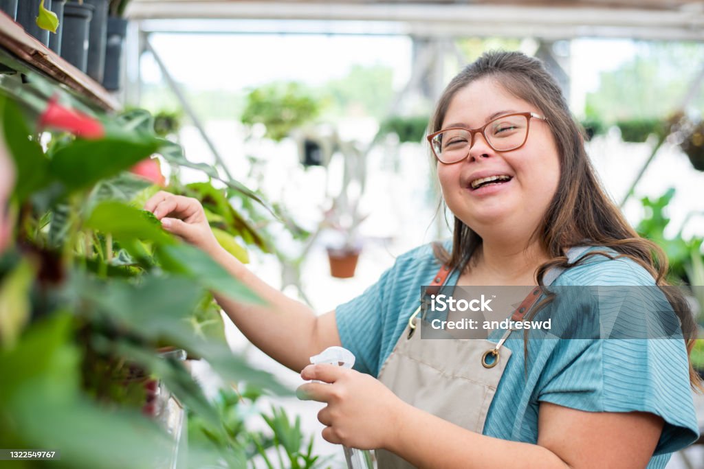 Social inclusion - woman with down syndrome working in small business woman with down syndrome florist working in flower shop Disability Stock Photo