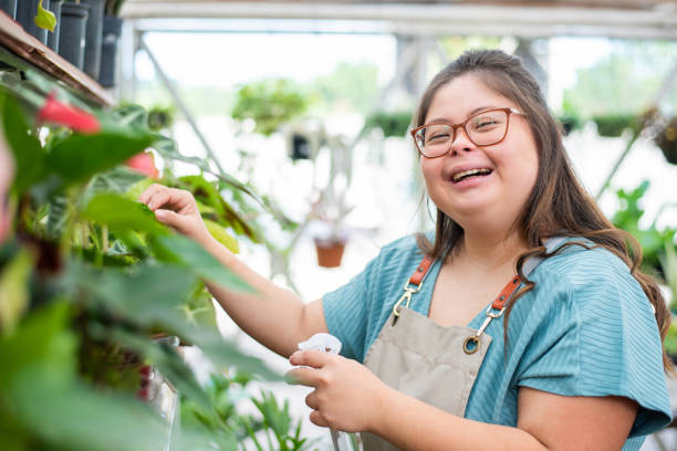 Social inclusion - woman with down syndrome working in small business woman with down syndrome florist working in flower shop disabled adult stock pictures, royalty-free photos & images