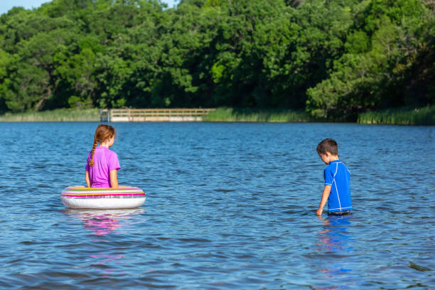 istock Two Children Playing In Water at Lake 1322549808