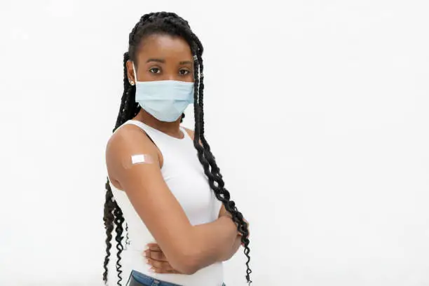 Photo of Afro american woman with band aid after vaccination: Selective focus. Vaccination concept.