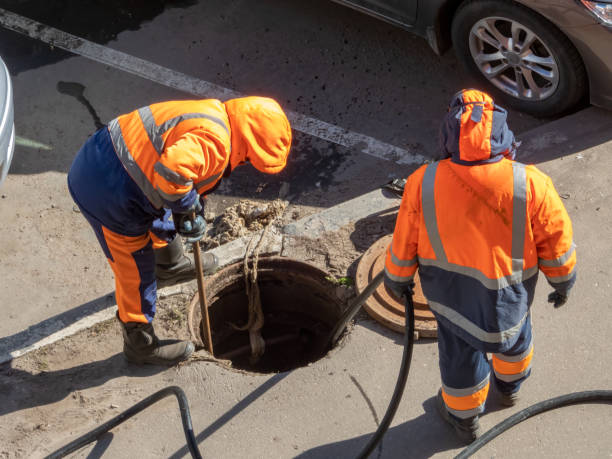 arbeiter über der offenen kanalluke - einsteigloch stock-fotos und bilder