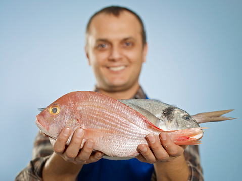 Male fish vendor smiling.