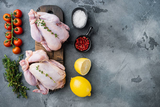 istock Fresh whole chicken carcass with herbs and ingredients, on gray background, top view with copy space for text 1322556329