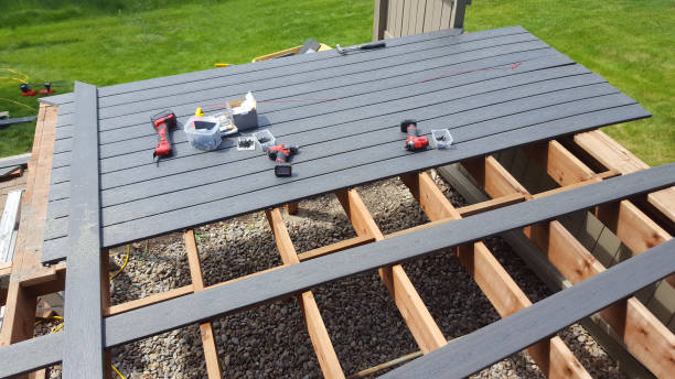 Partial Construction Of The New Composite Residential Deck New deck constructed from a Composite Decking Material. PVC Gray plastic with a wood grain. Supports and beams are real wood,cedar. canada close up color image day stock pictures, royalty-free photos & images