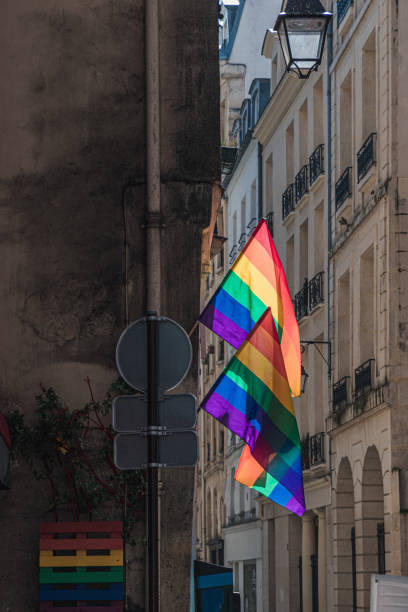 LGBTQ flags on corner of old building in Paris during pride. Transgender Pride flag stock photo