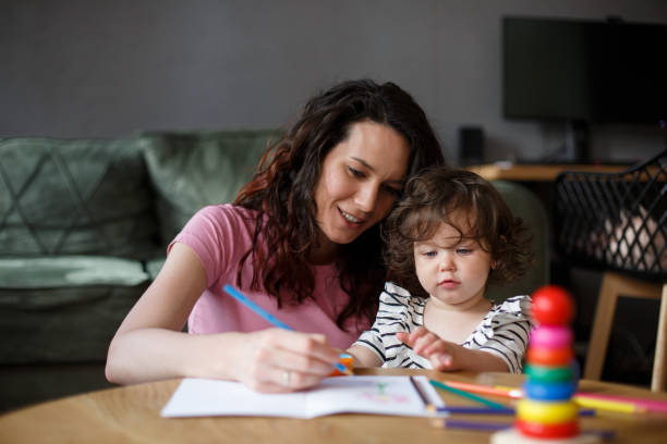 istock Mother learning her daughter how to color a coloring book. 1322565212