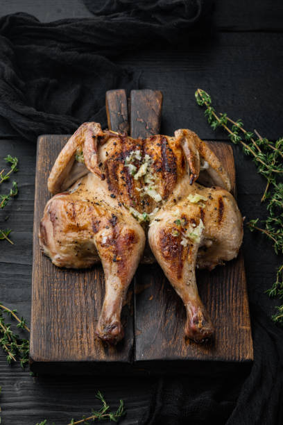 istock Freshly cooked rotisserie chicken, on black wooden table 1322565523