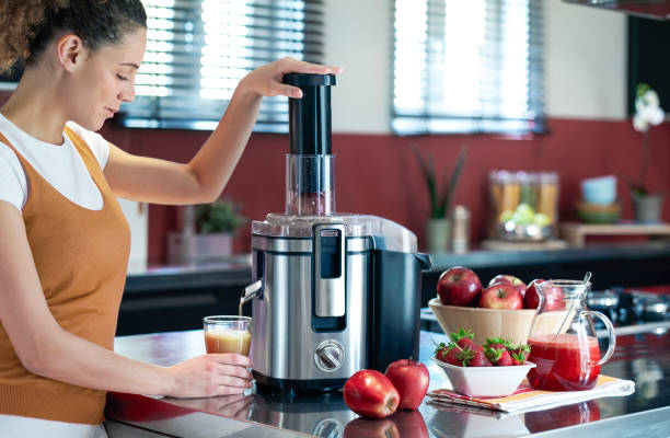 과일 주스를 만드는 젊은 여성 - electric juicer 뉴스 사진 이미지