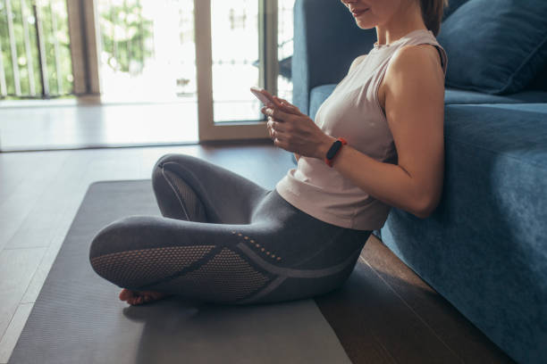 istock Unrecognizable Fitness Woman Using Mobile Phone Before Home Workout 1322570509