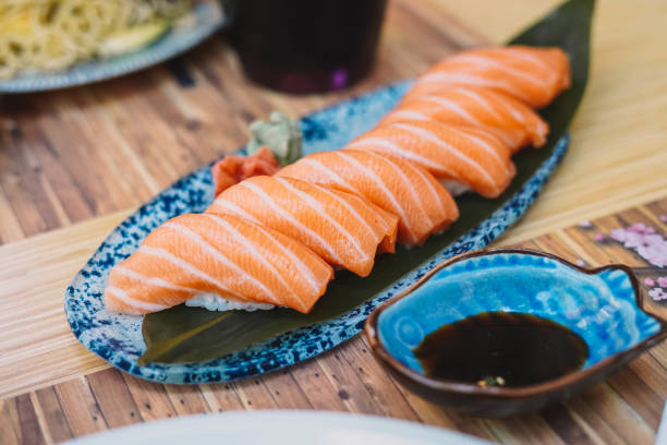 plato de niguiri de salmón con salsa de soja en un restaurante de sushi - niguiri sushi fotografías e imágenes de stock
