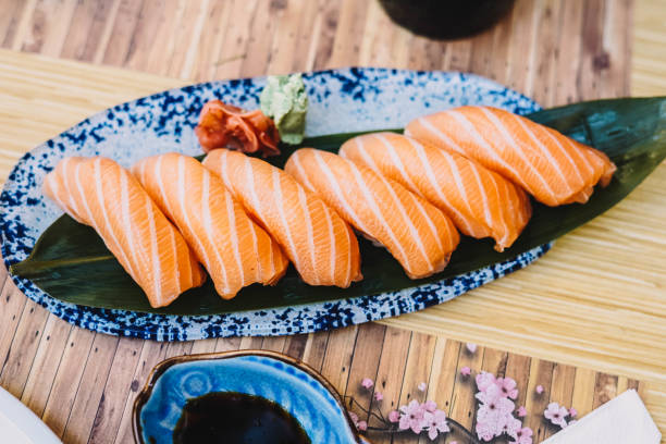 plato de niguiri de salmón con salsa de soja en un restaurante de sushi - niguiri sushi fotografías e imágenes de stock