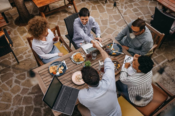 Always thinking about business Colleagues shaking hands during a meeting at an outdoor cafe business lunch stock pictures, royalty-free photos & images