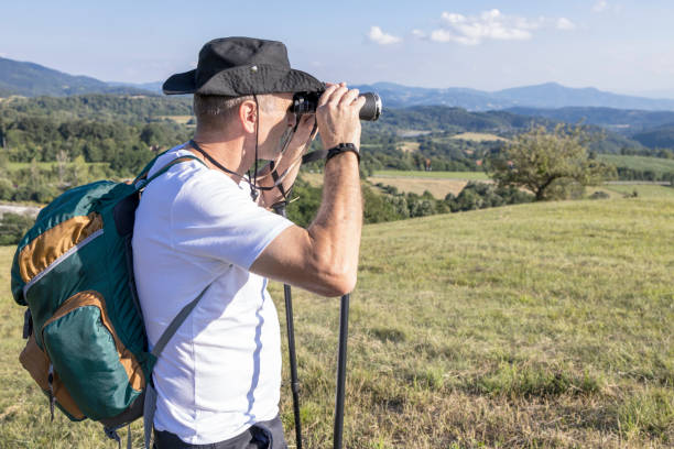istock Mature hiker using binoculars to observe surroundings 1322571897