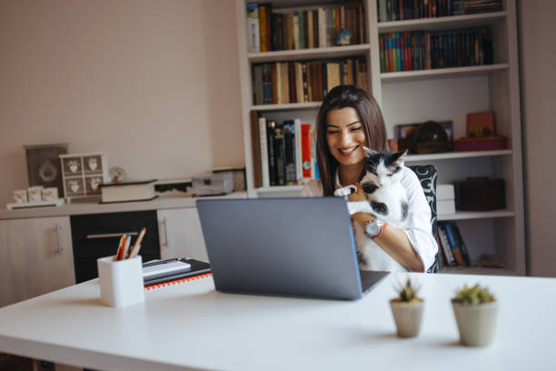 istock Young woman being interrupted by her cat while having video call at home 1322574942