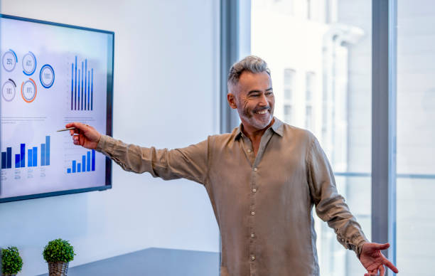 istock Mature businessman giving a presentation with graphs and charts. 1322578674