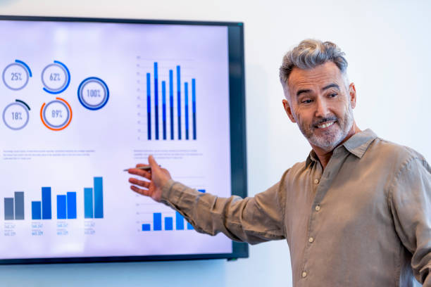 istock Mature businessman giving a presentation with graphs and charts 1322578676