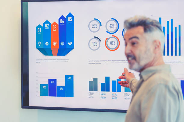 istock Mature businessman giving a presentation with graphs and charts. 1322578680