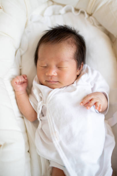 istock New born baby sleeping peacefully in a basket close up 1322580630