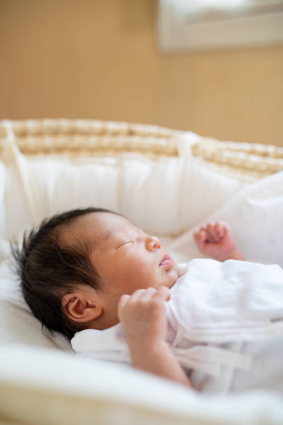 istock New born baby sleeping in a basinet crib close up 1322580635