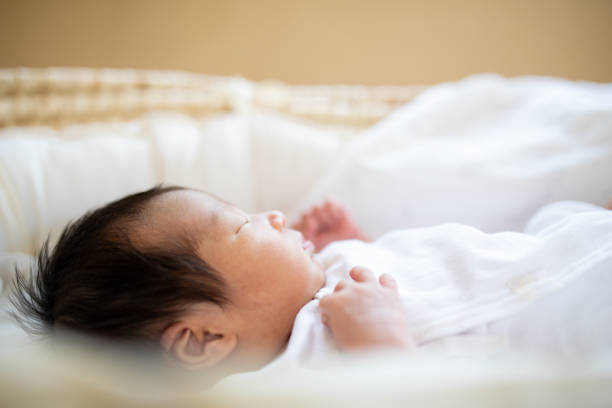 istock New born baby sleeping in a basinet crib close up 1322580641