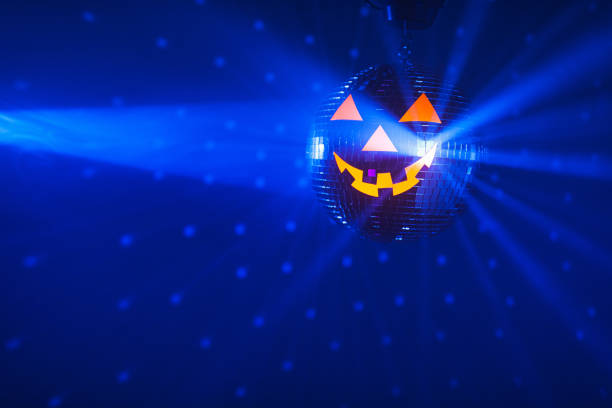 istock Halloween party pumpkin disco ball, blue shiny rays background 1322581567
