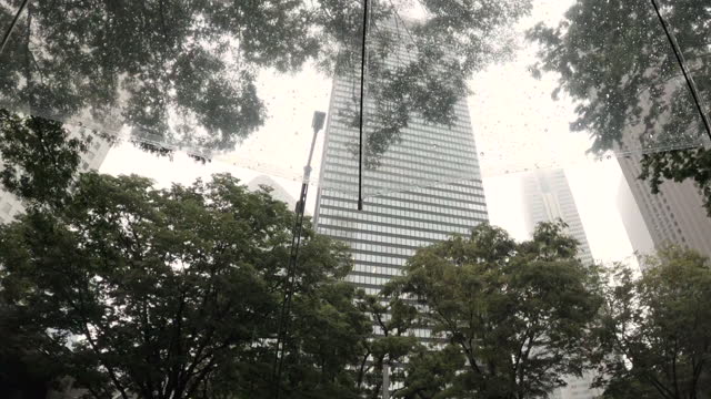 Looking up at a skyscraper through an umbrella on a rainy day
