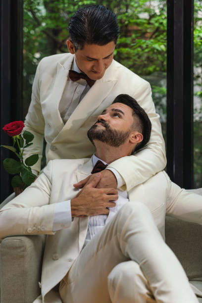 Caucasian LGBTQ gay couple have a goodtime together sitting in living room in wedding ceremony and marriage celebration. Concept of same sex homosexual relation Caucasian LGBTQ gay couple have a goodtime together sitting in living room in wedding ceremony and marriage celebration. Concept of same sex homosexual relation civil partnership stock pictures, royalty-free photos & images