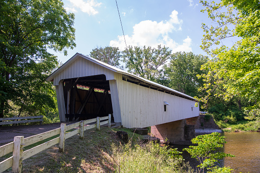 Darlington Covered Bridge over Sugar Creek in Franklin Township, Montgomery County, Indiana. \nThe bridge was built in 1868 and is a single span, Howe truss structure. Total length: 169.0 feet.\nPosted to the National Register of Historic Places on November 28, 1990