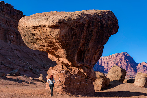 Woman looking up at Balanced Rock, Marble Canyon, Arizona, USA