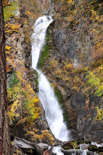 istock A small waterfall flowing down from the mountains into an autumn valley in a violent cascade. 1322602731