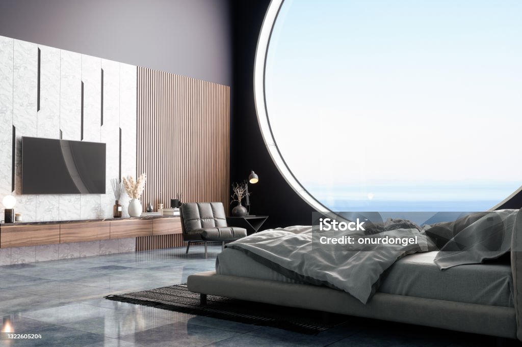 Luxurious Bedroom Interior With Bed Furniture, Armchair And TV Set In Holiday Villa Or In Hotel. Seaview From The Window. Luxury Stock Photo
