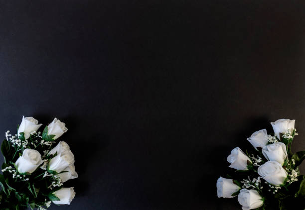 istock Flat Lay, postcard for death, funeral. White roses on a black background 1322614015