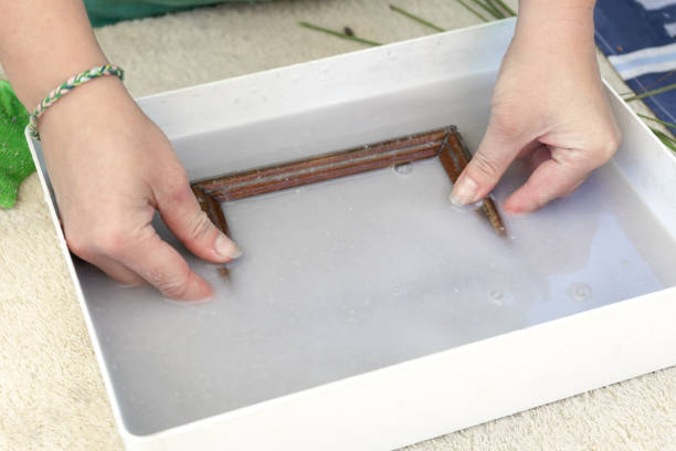 istock Woman holding frame for making paper sheets from waste paper pulp. Selective focus. Decorative and applied art. Recycling concept, ecology. 1322615310