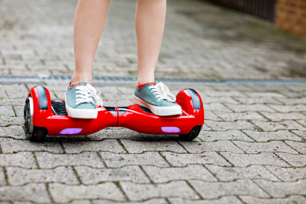 istock Close-up of kid boy on hover board. Child driving modern balance hoverboard. Excercise and sports for children, outdoor activity for young kids. 1322620449