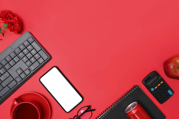istock Mock up mobile phone, notebook, red can, calculator, coffee cup and apple on red background. Copy space. 1322621442