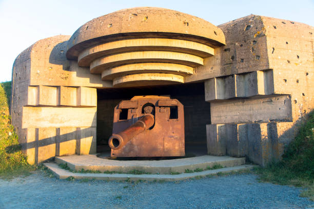 colocação de armas em omaha beach. abrigo anti-bombas com arma de artilharia alemã de longo alcance da 2ª guerra mundial em longues-sur-mer, na normandia. - france sea allied forces atlantic ocean - fotografias e filmes do acervo