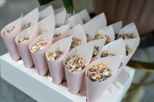 Wedding confetti in small cone paper holders natural flower petals ready to throw over bride and groom after ceremony.