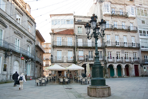 Vigo, Spain - January 11, 2021: Constitución square in old town Vigo, Pontevedra province, Galicia, Spain. People walking by, sidewalk cafes.
