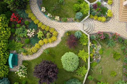 Garden with walkways and green grass. Photo taken from above drone
