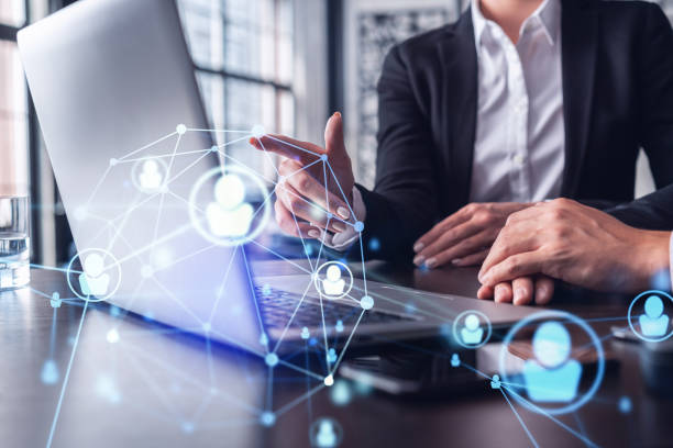 istock Two HR specialists analyzing the recruitment market using laptop to boost the intern program at international consulting company. Social networking hologram icons. 1322630105